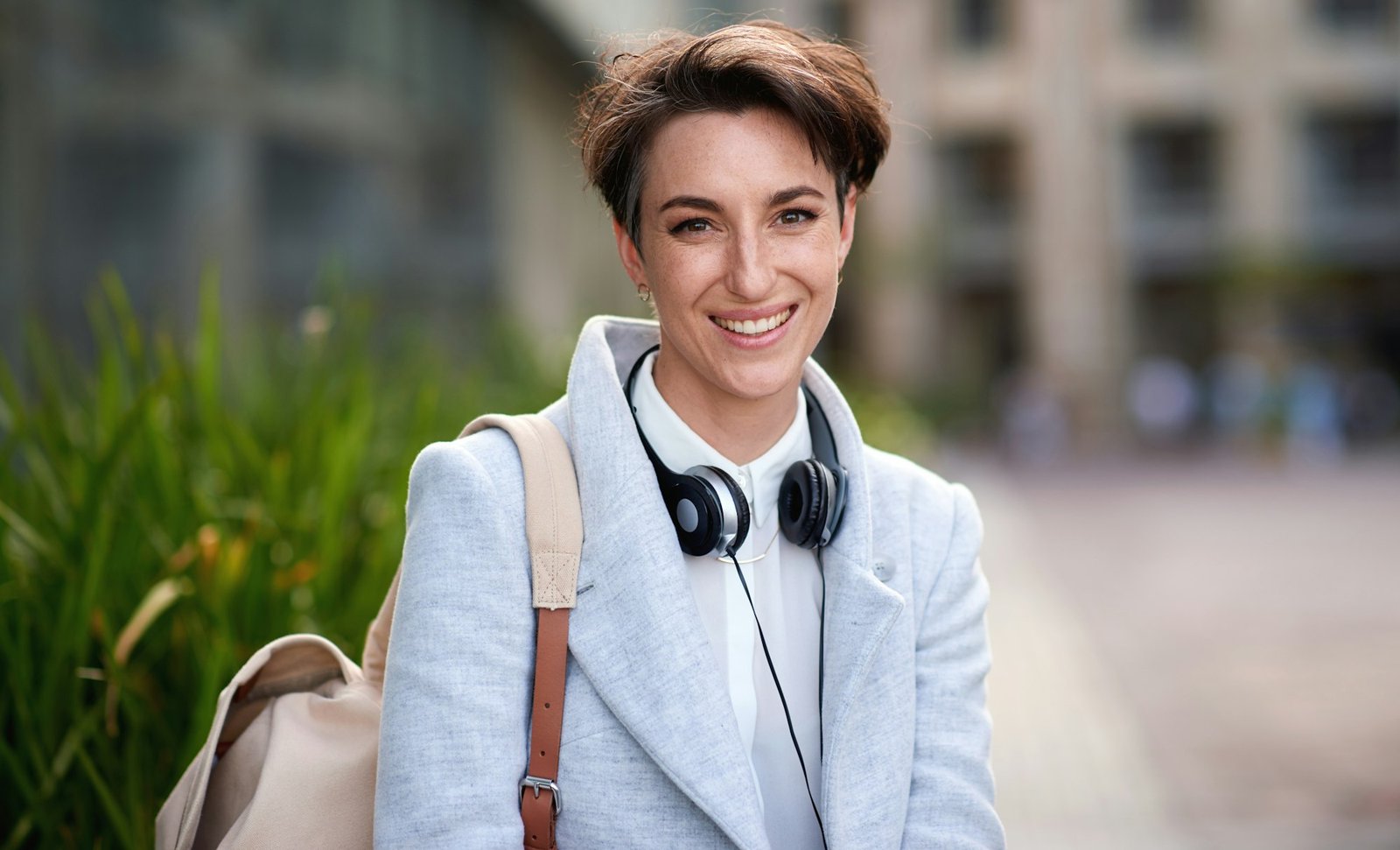 Portrait confident young business woman smiling in city success testimonial