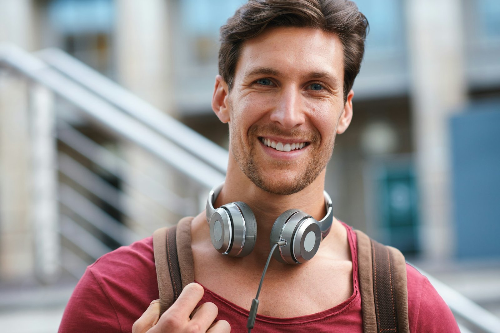 Portrait happy young man smiling confident feeling positive in city urban success testimonial